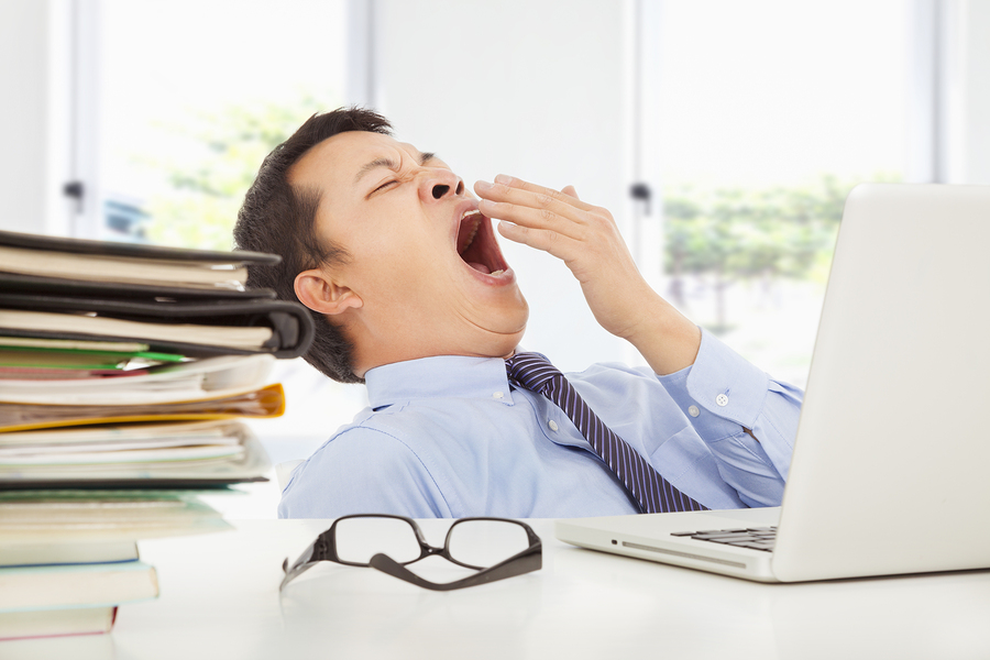 Exhausted Young Businessman Yawning At Work
